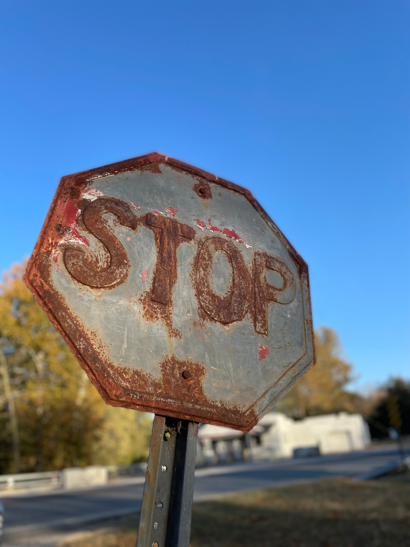 Shanna D. Olds' photograph of a weathered, rusted STOP sign against a clear blue sky.